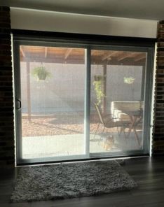 Malibu living room featuring new screen roller shades, patio furniture visible through the glass doors