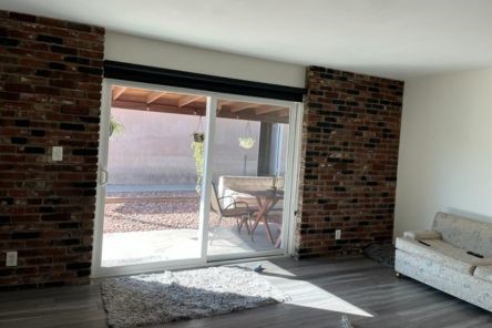 Malibu living room featuring new screen roller shades, patio furniture visible through the glass doors